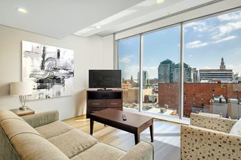 a living room with a couch and a television and a view of the city